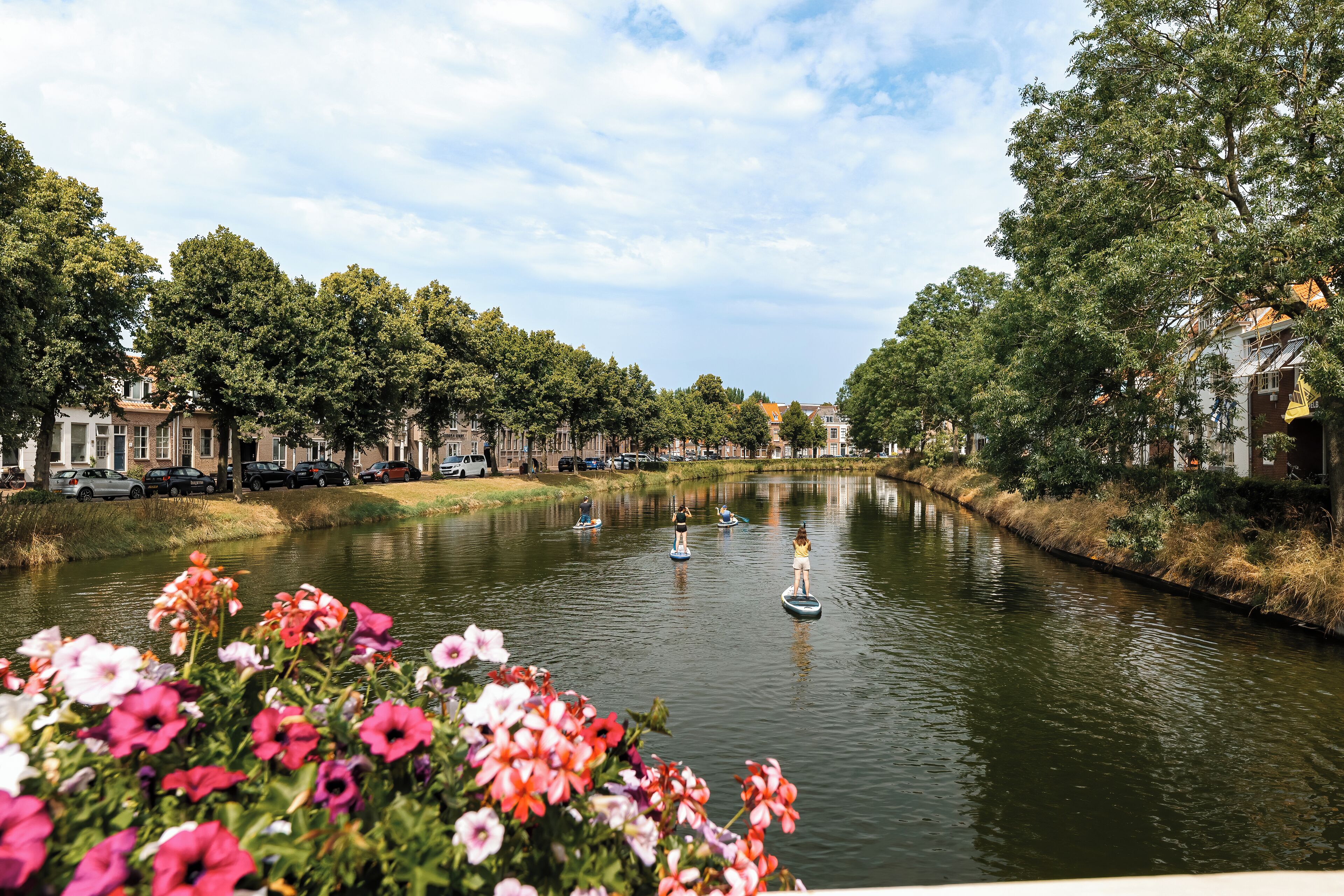 A canal with boats, surrounded by trees and buildings.