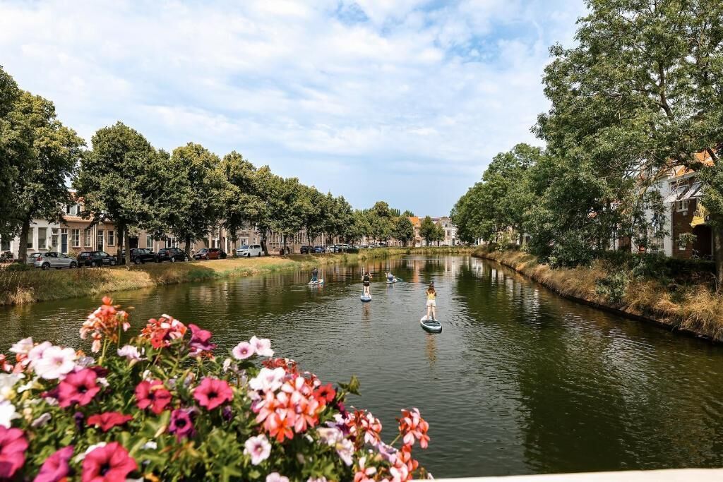 A canal with boats, surrounded by trees and buildings.
