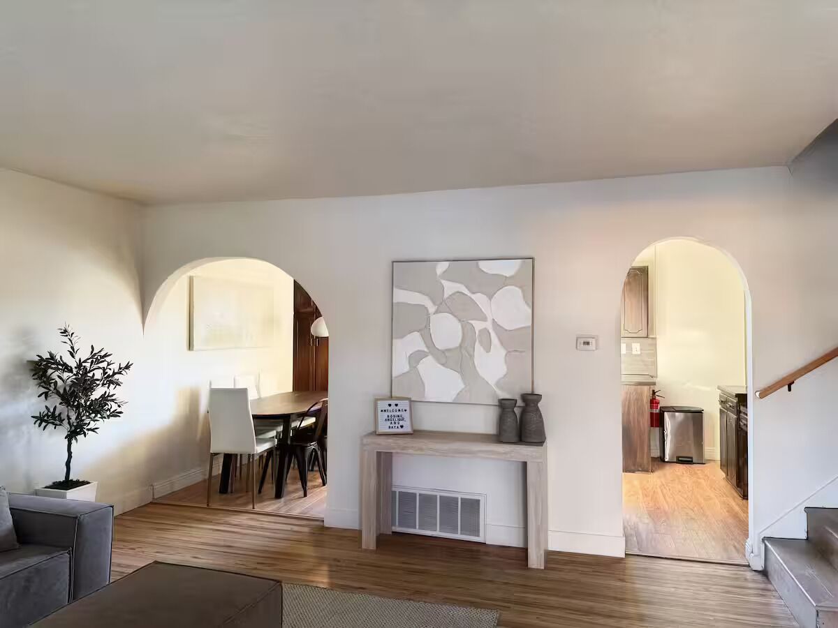 A living room with a fireplace, a dining area, and an open kitchen.