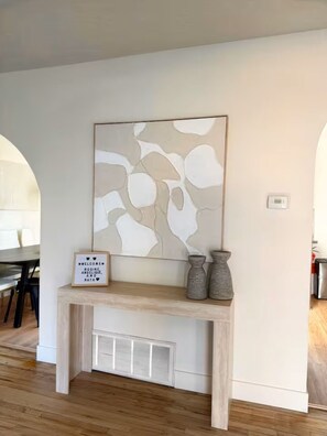 Ein modernes Interieur mit einer Konsolentisch, abstrakter Kunst und einem Willkommensschild.