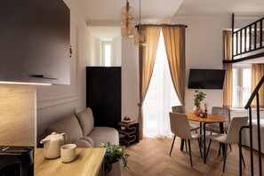 Suíte estúdio superior, ar-condicionado, no mezanino | Área de estar | TV de tela plana