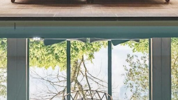 A modern bedroom with a bed, a hanging light fixture, and large windows. - Hotel de Sterrenberg (Otterlo)