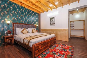 A bedroom with a wooden bed, a patterned wall, a wooden ceiling, and a red rug.