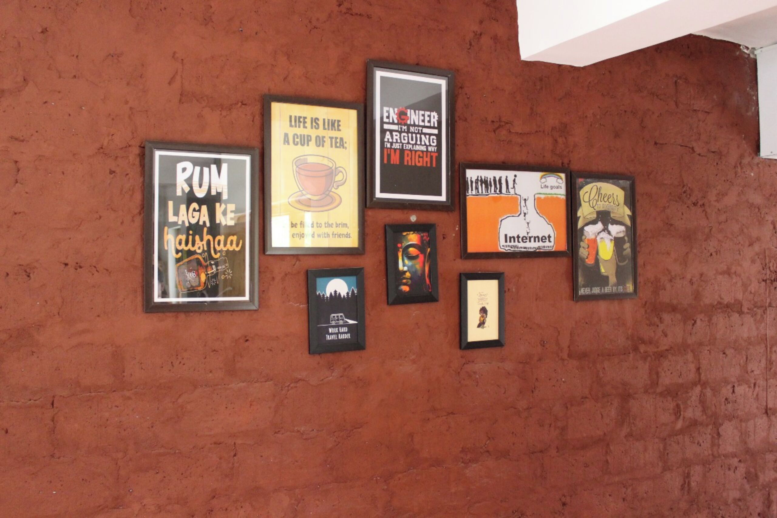 A wall with seven framed posters, each with different text and graphics.