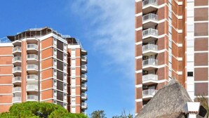 Un edificio alto con varios balcones y un cielo azul despejado.