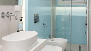 A modern bathroom with a white sink, a bidet, and a glass-enclosed shower. - Lemon pie by halu! Charming studio next to Aristotelous Square (Thessaloniki)