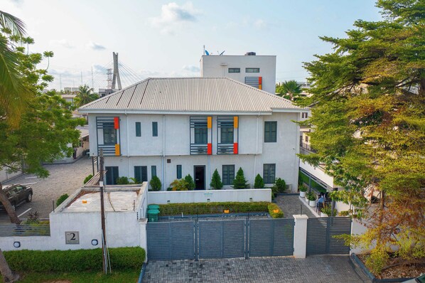 A modern two-story building with a flat roof, multiple windows, and a gated entrance. - The Linkview Shortlet Apartment (Lekki)
