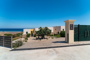 Ein moderner Gebäudekomplex mit geschlossenem Eingang, freiem Blick auf den Strand und einem Schild mit der Aufschrift 'Mare Blue 1'.