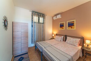 Un dormitorio con cama, mesitas de noche, armario y cortinas.