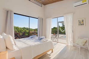 Une chambre d’hôtel avec un lit, une chaise et une vue sur un balcon équipé d’un hamac.