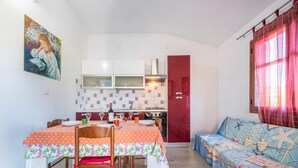 Un espace de vie compact comprenant un coin repas, une kitchenette et un canapé.