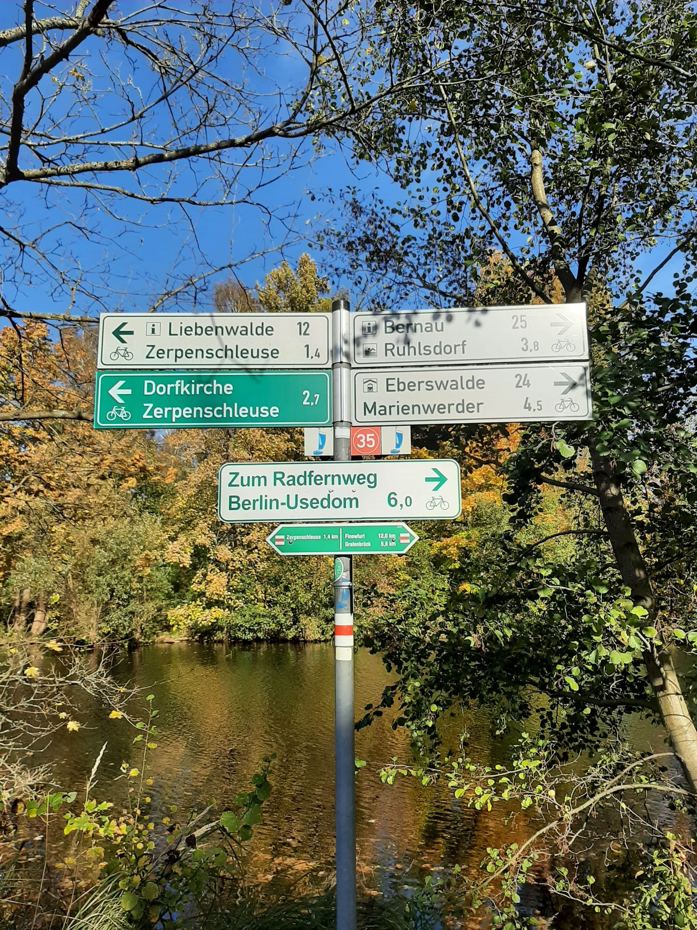 Een richtingsbord met meerdere pijlen dat afstanden en richtingen naar verschillende locaties aangeeft.