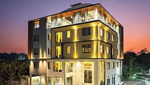 A multi-story building with balconies, large windows, and a well-lit facade. - Skyearth Hotel (Indore)