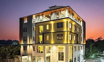 A multi-story building with balconies, large windows, and a well-lit facade.