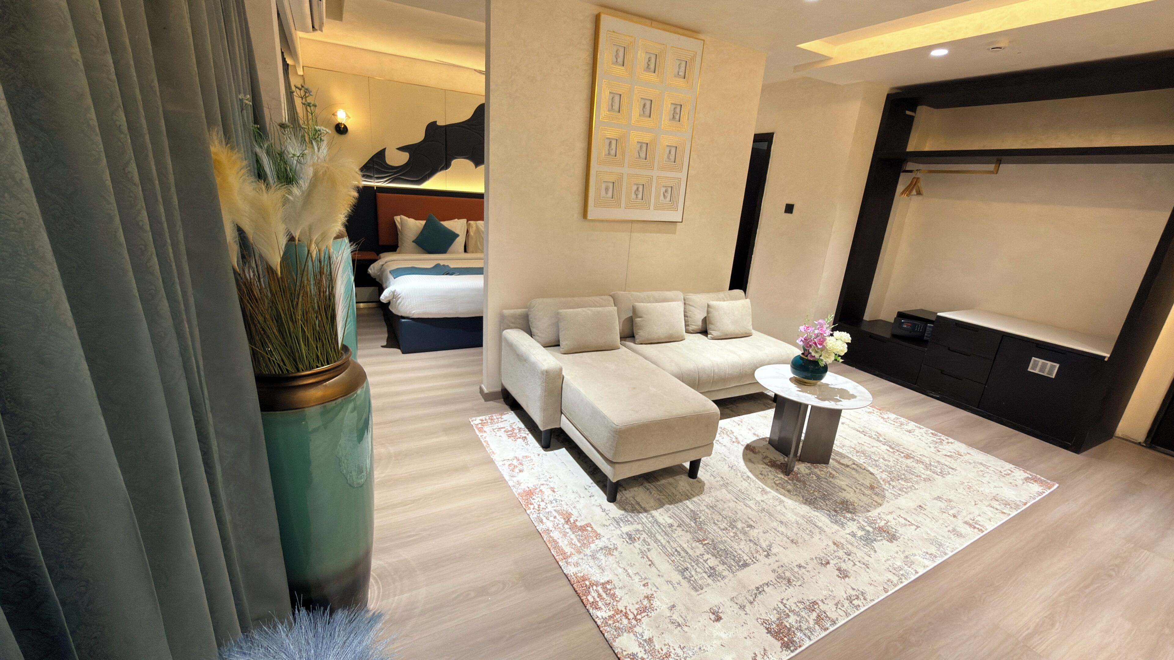 Un salon moderne avec un canapé d’angle, une table basse et un vase décoratif.