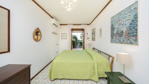 Ein Schlafzimmer mit einem Bett, einem Schminktisch, einer Lampe und einem Bild an der Wand.