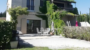 Un bâtiment à deux étages doté d’un patio, de mobilier d’extérieur et d’une échelle appuyée contre le mur.