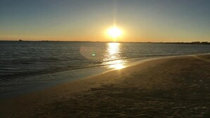 A beach with the sun setting over the water. - Villa Solaria - Giardino Privato and Aria Condizionata (Porto Cesareo)