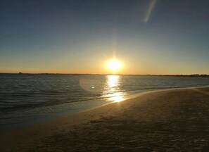 A beach with the sun setting over the water. - Villa Solaria - Giardino Privato and Aria Condizionata (Porto Cesareo)