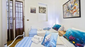 A hotel room with a bed, two bedside tables, a window with curtains, and artwork on the walls. - Villa Solaria - Giardino Privato and Aria Condizionata (Porto Cesareo)