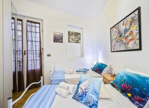 A hotel room with a bed, two bedside tables, a window with curtains, and artwork on the walls. - Villa Solaria - Giardino Privato and Aria Condizionata (Porto Cesareo)