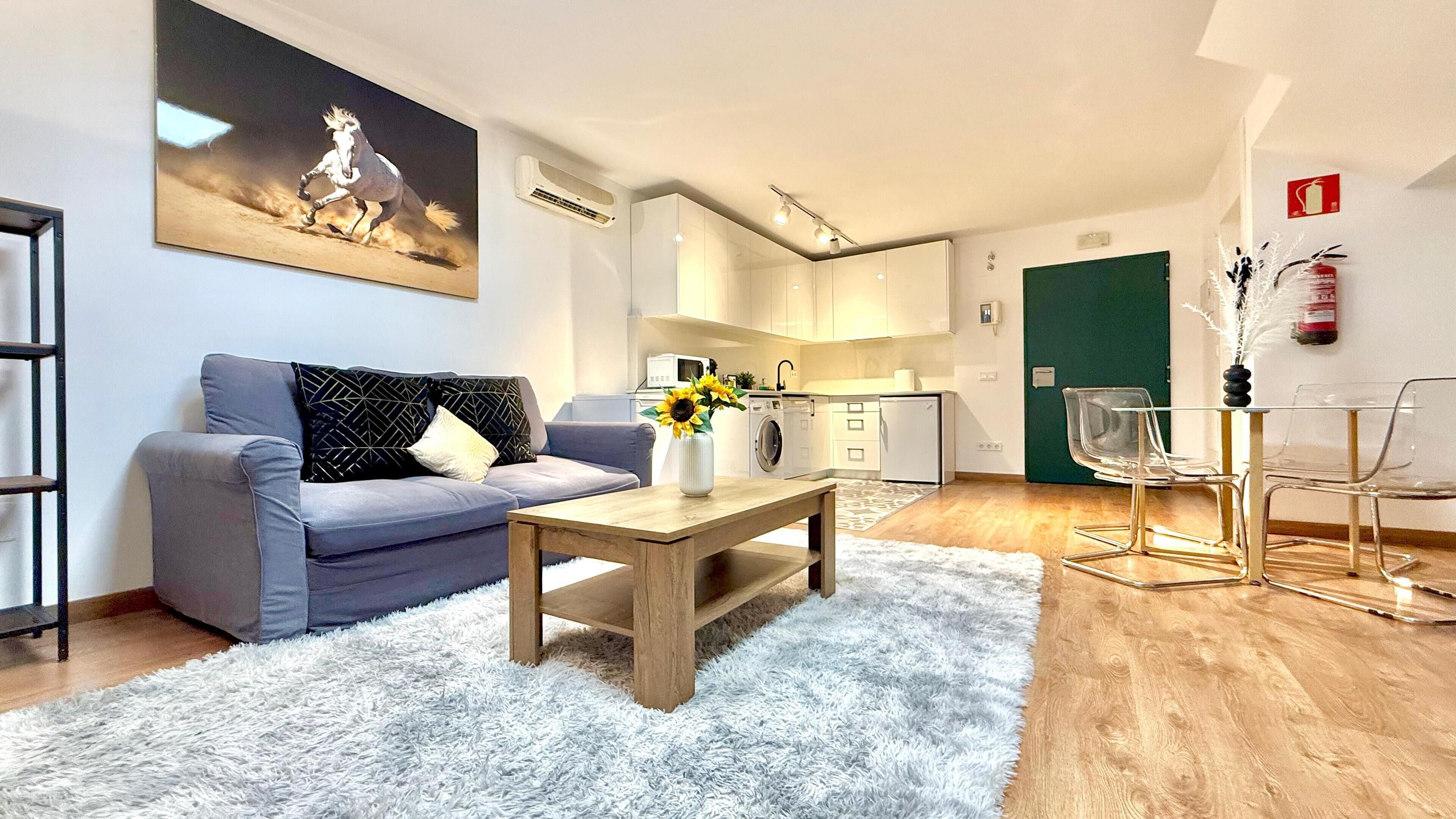 A modern living room with a grey sofa, a wooden coffee table, and a white furry rug.