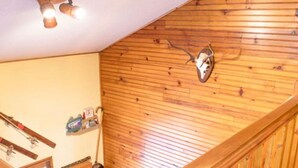 A wooden staircase with a wooden handrail and a ceiling light fixture. - Chalet at 50 meters from the ski slopes "Les Angles (Les Angles)