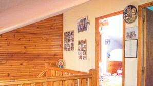 A wooden staircase leading to a second floor, with a door on the right and a wall with photos and a clock. - Chalet at 50 meters from the ski slopes "Les Angles (Les Angles)