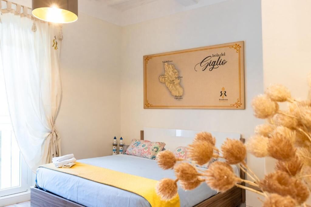 Ein Schlafzimmer mit einem Bett, einer Karte an der Wand und einem Fenster mit Vorhängen.