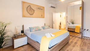 A bedroom with a bed, bedside table, and a large framed map on the wall. - Residenza Ricasoli (Grosseto)