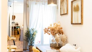 A modern interior with a wooden dining table, yellow chairs, a potted plant, and framed artwork on the walls. - Residenza Ricasoli (Grosseto)