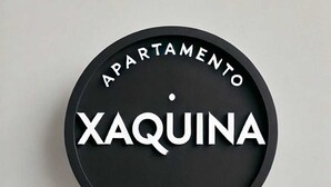 A circular sign with the words "APARTAMENTO" at the top and "XAQUINA" in the center. - Xaquina Apartment (Melide)