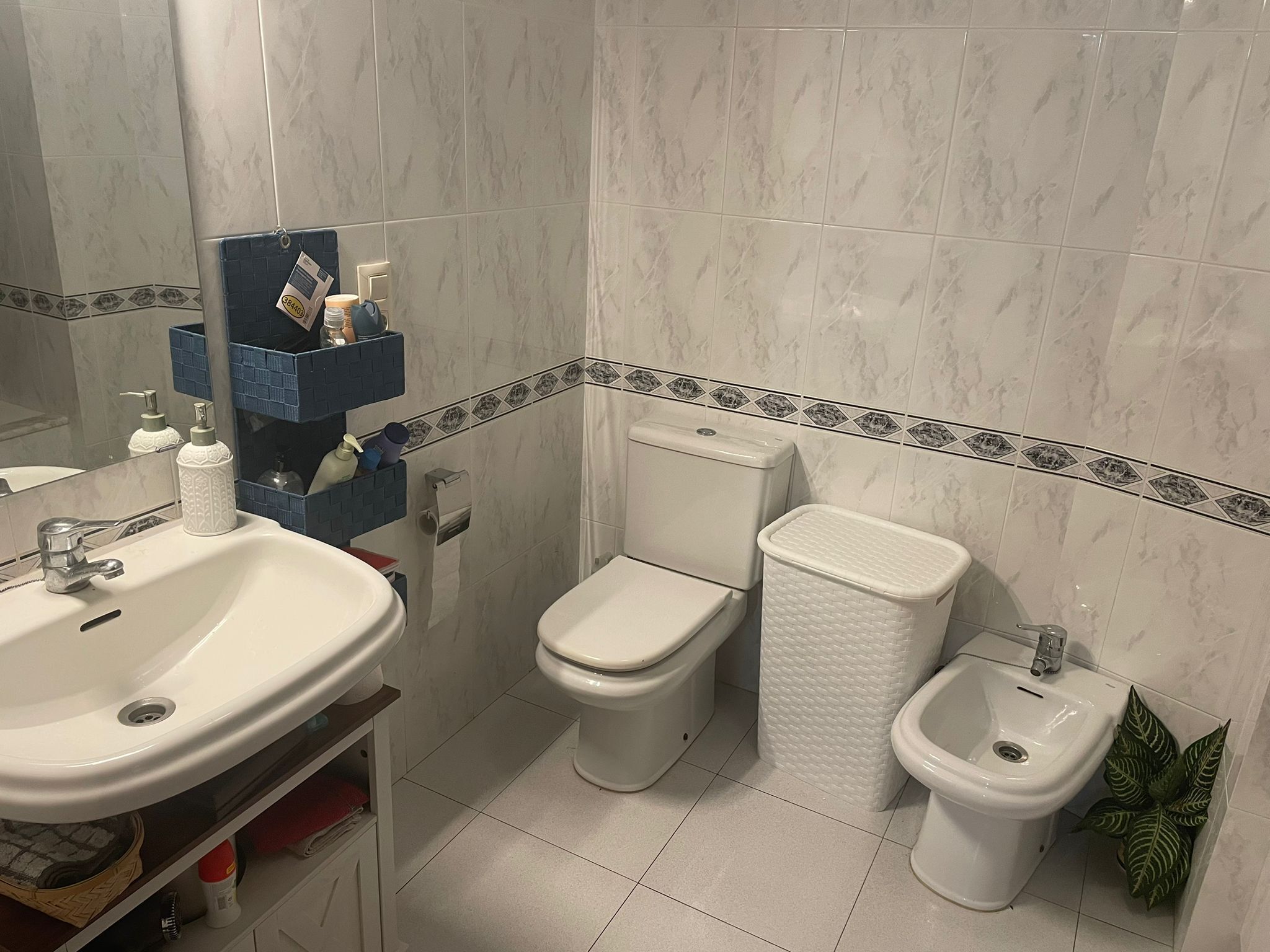 Une salle de bain équipée d’un lavabo, de toilettes, d’un bidet et d’un miroir.