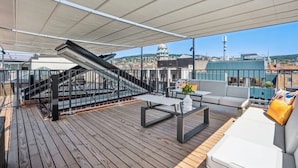 A rooftop deck with a wooden floor, outdoor seating, a staircase, and a view of the cityscape. - Old Town Penthouse | 360° Views | Rooftop Terrace (Zürich)