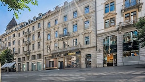 A multi-story building with a storefront labeled 'TAGHeuer' and a visible entrance. - Old Town Penthouse | 360° Views | Rooftop Terrace (Zürich)