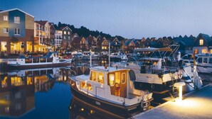 Una marina con barcos amarrados, rodeada de edificios residenciales.