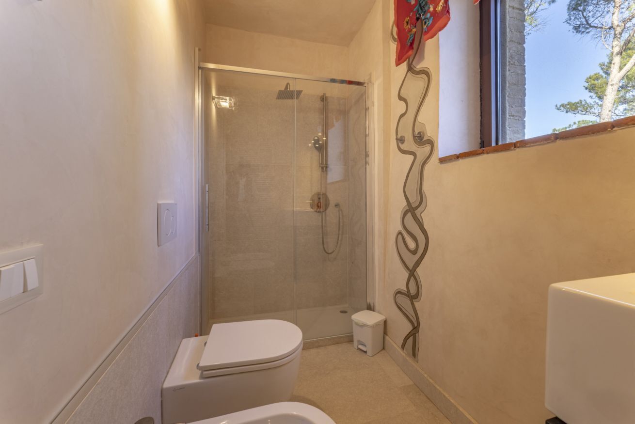 A bathroom with a toilet, a shower, and a small step stool.
