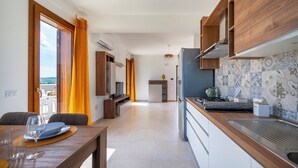 Una cucina moderna con mobili in legno, forno integrato e pannello di rivestimento piastrellato.