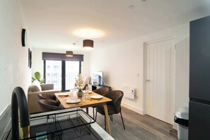 Eine moderne Küche mit Essbereich, einem Kühlschrank und einem Fernseher.