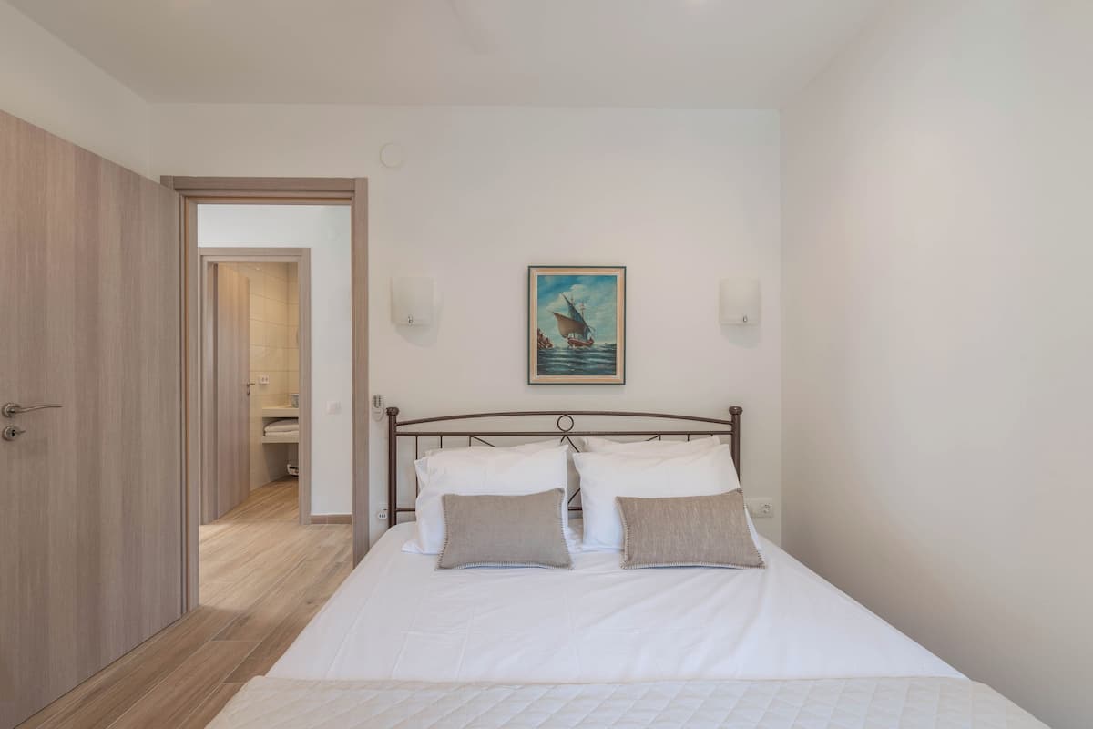 Une chambre à coucher avec un lit, un tableau et une armoire en bois.