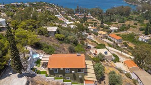 Zona residencial costera con casas, vistas despejadas del mar y un paisaje montañoso.