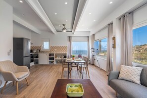 Ein modernes Wohnzimmer mit einer Couch, einem Esstisch und einer Küchenzeile.