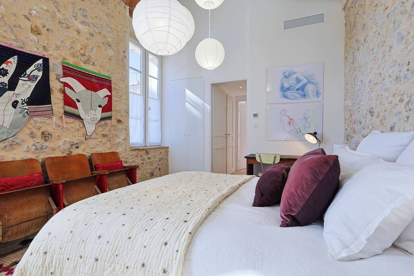 Una camera da letto con un letto, una scrivania e delle sedie.