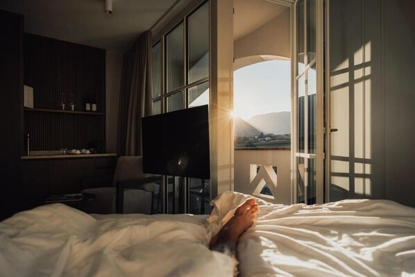 Een hotelkamer met een bed, een televisie, een bureau en uitzicht op de omgeving.