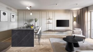 A modern living room with a large TV, a dining area, and a kitchen with a marble island. - Lingers Suites & Residence (Appiano Sulla Strada del Vino)