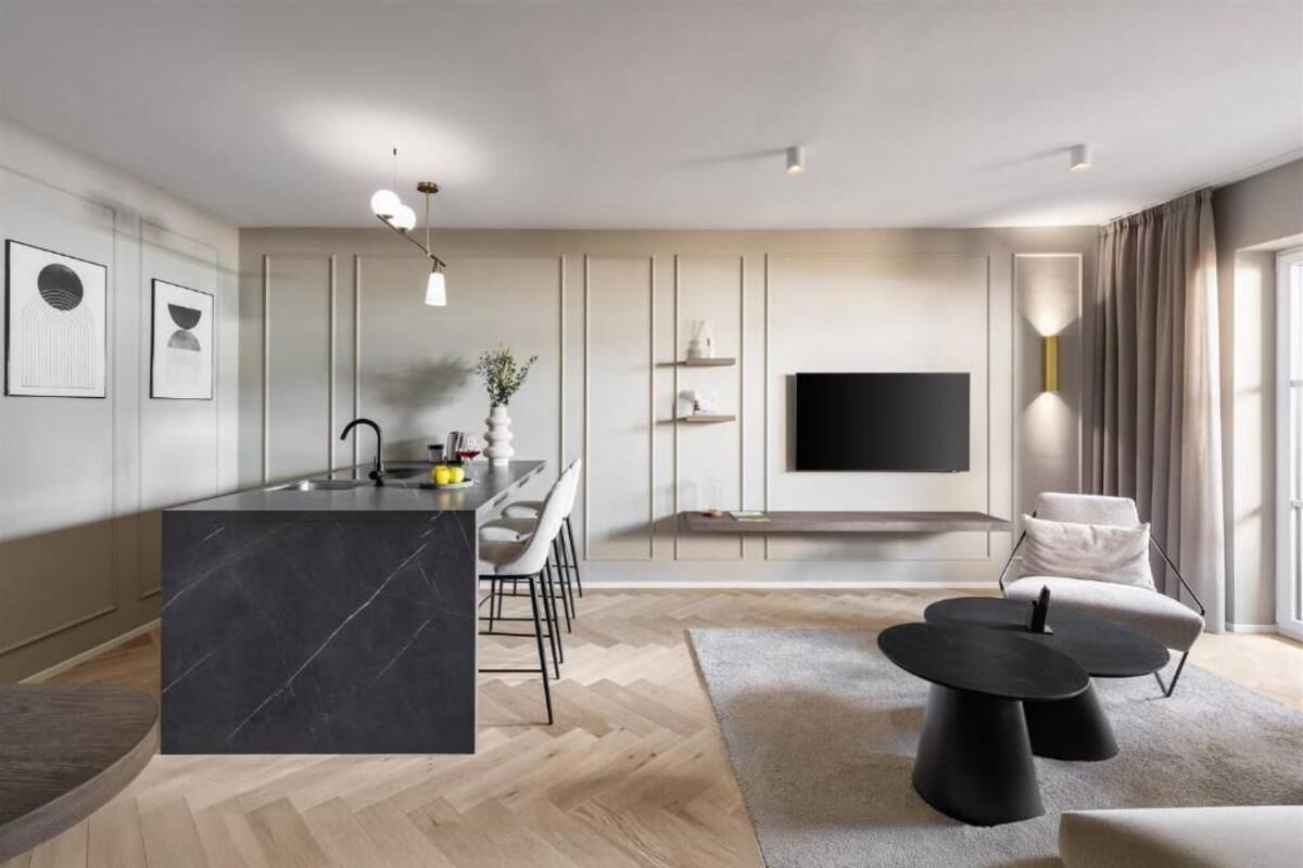 Een moderne woonkamer met een grote televisie, een eethoek en een keuken met een marmeren kookeiland.