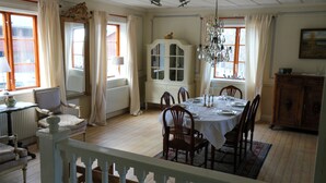 A dining room with a table set for four, surrounded by wooden chairs, a white cabinet, and a chandelier. - Spacious Farmhouse – Skiing, Forest & Town. Pet-friendly! (Svenstavik)