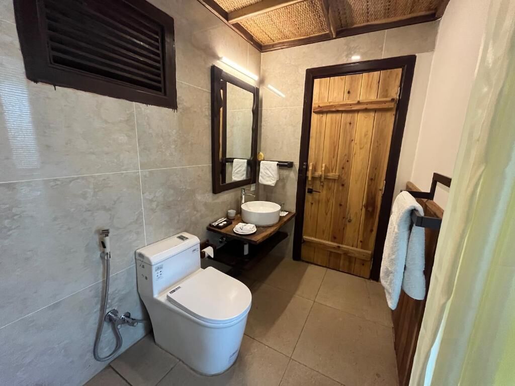 A bathroom with a toilet, sink, and shower.