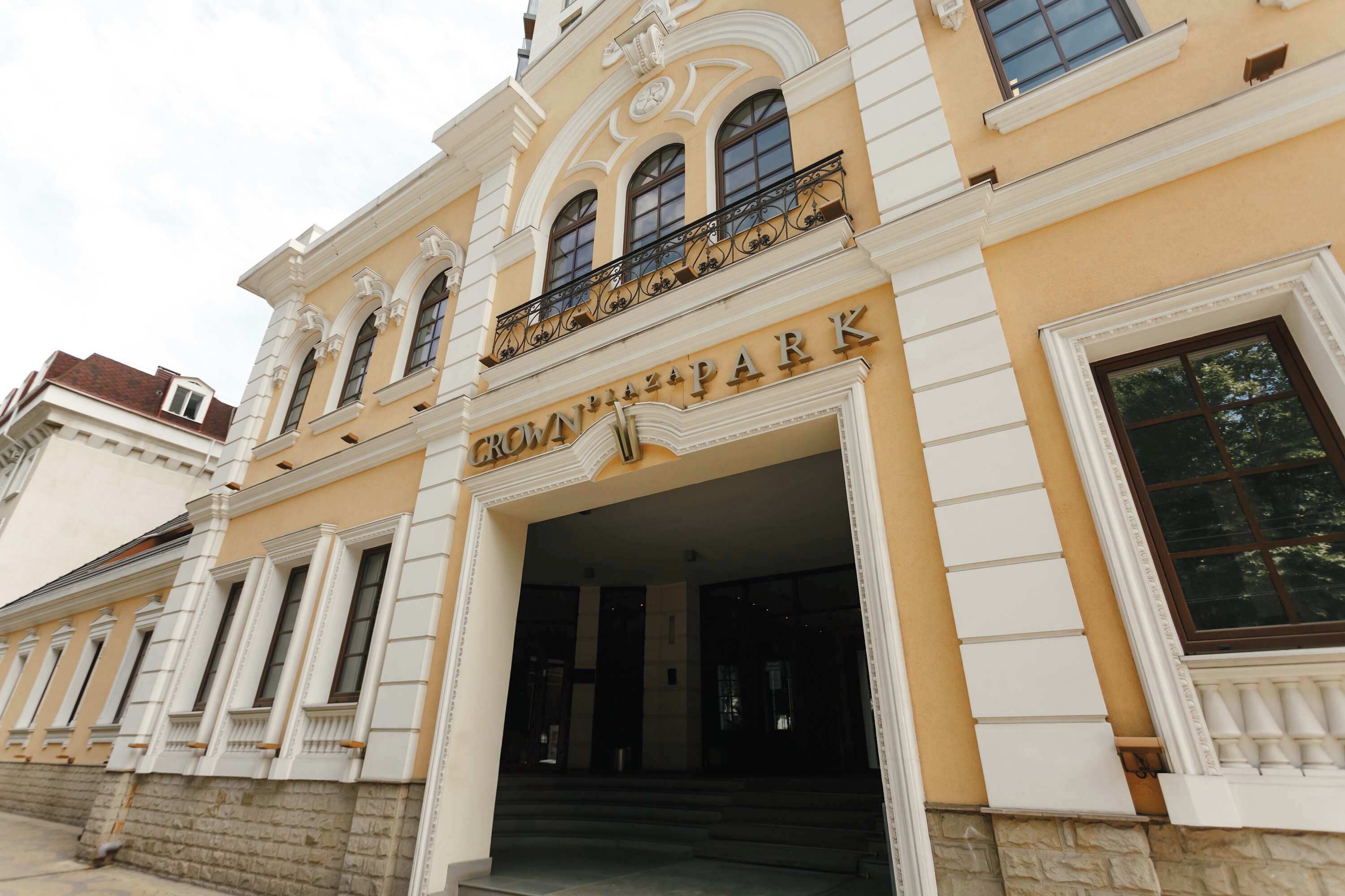 A building with the sign "Crown Plaza Park" above the entrance, featuring classical architecture with columns and a balcony.