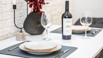 A neatly set dining table with plates, cutlery, and a bottle of wine, suggesting a formal dining experience.
